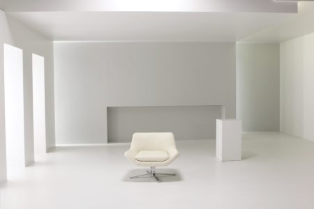 a setup of white room with an armchair in studio for shooting a movie